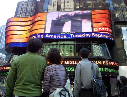 'People in Times Square watch the World Trade Center fire live"